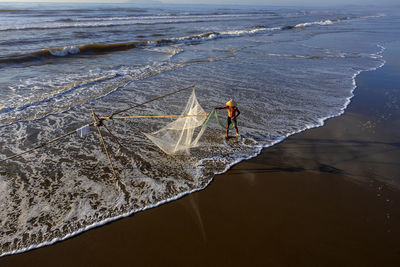 Fisherman working with net at beach