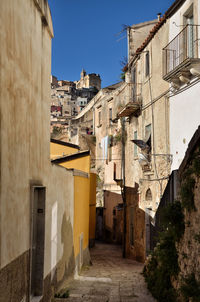 Street amidst buildings in town against clear sky