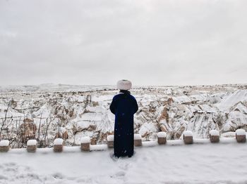 Person standing on snow covered field