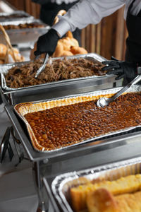 Midsection of people serving food in kitchen