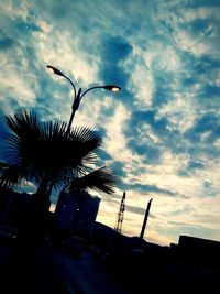 Low angle view of silhouette trees against cloudy sky