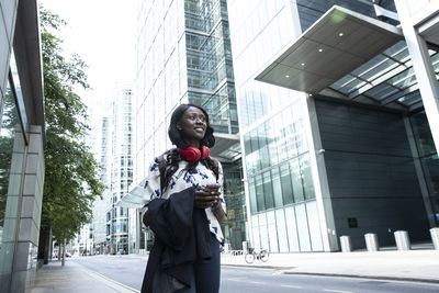 Woman standing against buildings in city