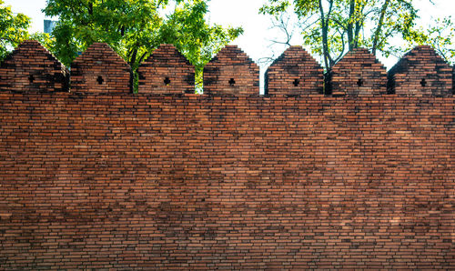 Low angle view of brick wall by building