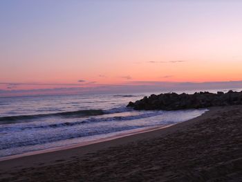 Scenic view of beach against sky during sunset