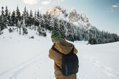 Rear view of person standing on snow covered field