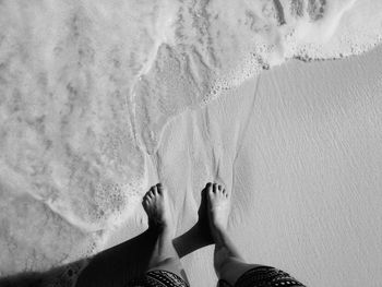 Low section of woman standing on beach