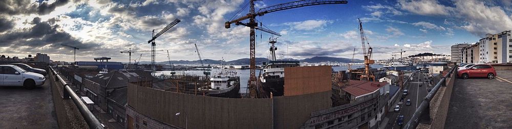 Panoramic view of harbor against cloudy sky