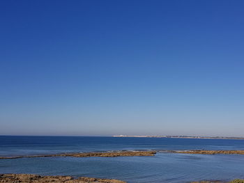 Scenic view of sea against clear blue sky