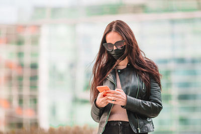 Young woman using mobile phone outdoors