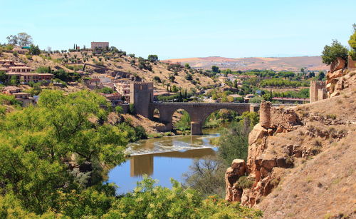 Scenic view of landscape and river against clear sky