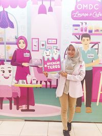 Portrait of a smiling young woman standing in store