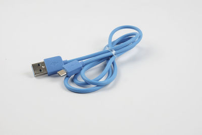 Close-up of blue usb cable over white background
