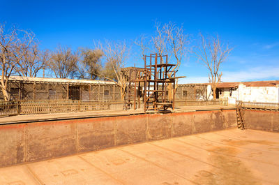 Bare trees against built structure