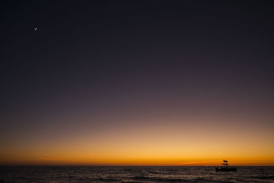 Scenic view of sea against clear sky during sunset