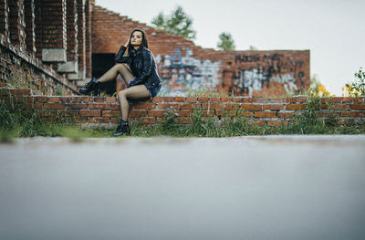 Woman sitting against wall