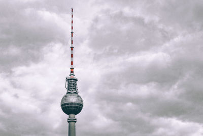 Television tower against cloudy sky