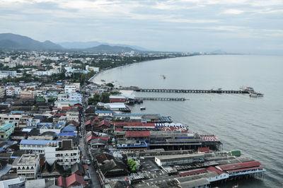 High angle view of city by sea against sky