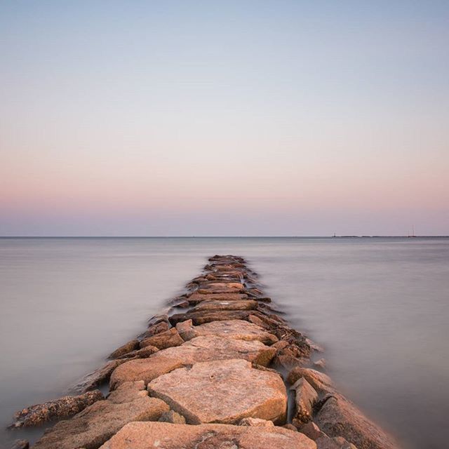 sea, water, horizon over water, tranquil scene, tranquility, scenics, beauty in nature, clear sky, copy space, nature, beach, sunset, rock - object, shore, idyllic, sky, calm, remote, outdoors, non-urban scene