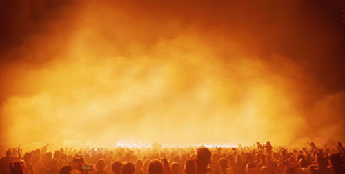 Crowd at music concert against sky at night