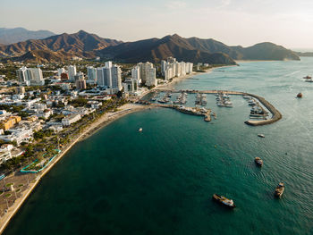 High angle view of city by sea against sky