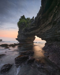 Scenic view of rock formation in sea against sky