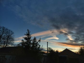 Low angle view of silhouette house against sky during sunset