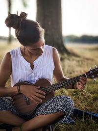 Midsection of woman playing guitar