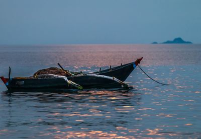 Fishing boat in sea against clear sky