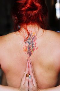 Rear view of shirtless woman with tattoo