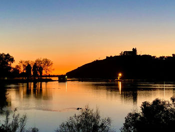 Scenic view of lake against orange sky