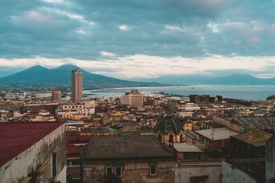 High angle view of city by sea against sky