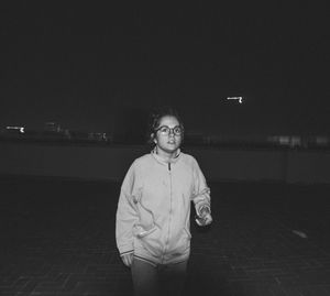 Portrait of young man standing against illuminated sky at night