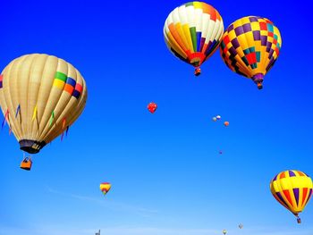 Hot air balloons flying against blue sky