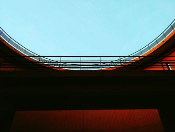 Low angle view of footbridge against clear blue sky