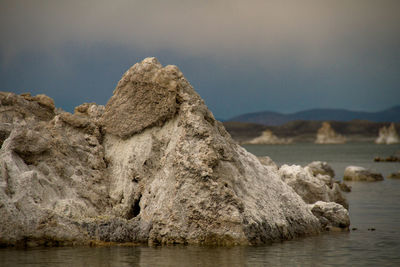 Rock formation in sea against sky