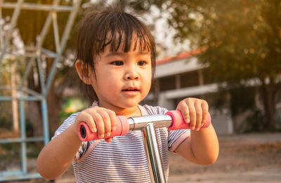 Close-up of cute girl with push scooter