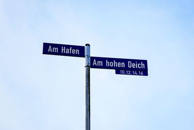 Low angle view of road sign against sky