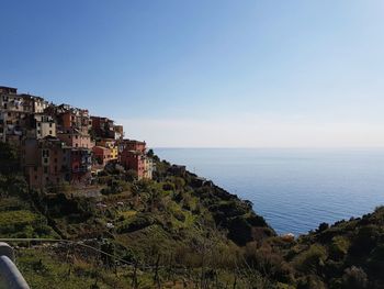 Scenic view of sea by buildings against clear sky