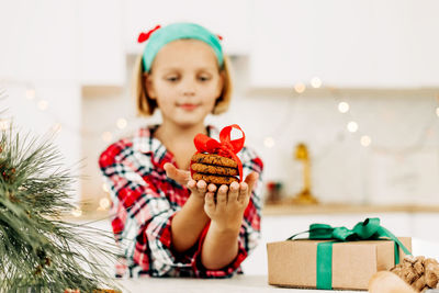 Cute girl holding cookies at home