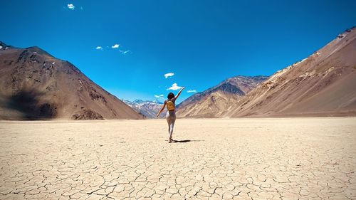 Full length of woman on arid landscape against sky