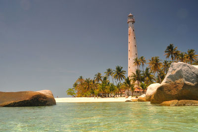 Scenic view of rocks by sea against sky