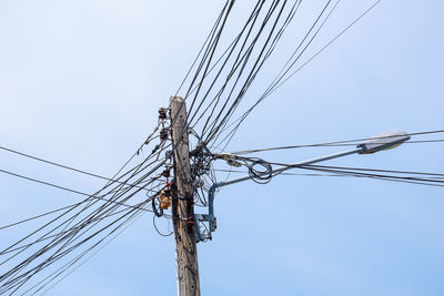 Low angle view of electricity pylon against clear sky