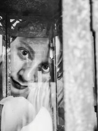 Portrait of man looking through window