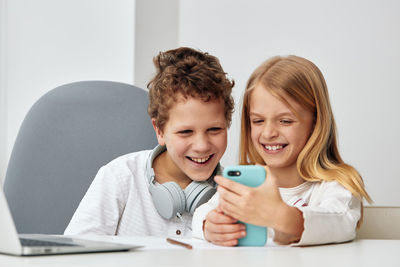 Young woman using mobile phone while sitting at home