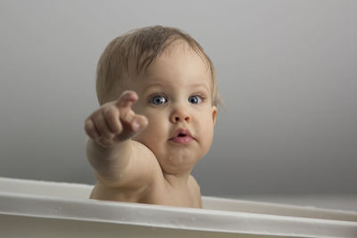 Portrait of cute shirtless baby boy in bathtub