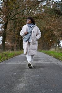 Portrait of young woman standing on road