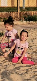 Siblings playing on sand at beach