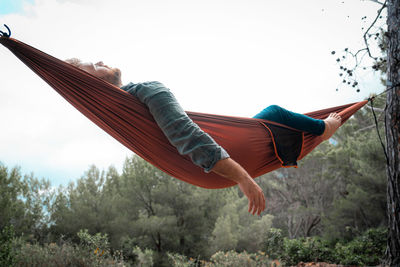 Low angle view of man lying on hammock