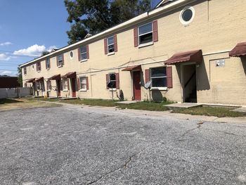 Houses by road against sky in city