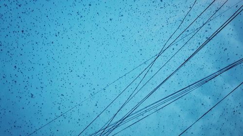 Low angle view of birds flying against blue sky